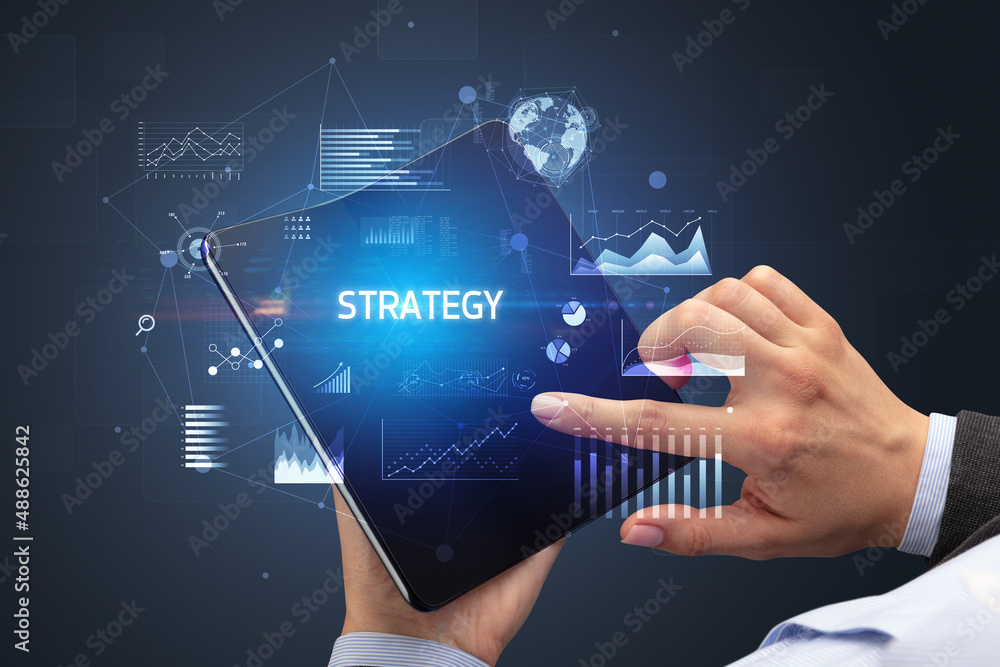Obraz premium Businessman holding a foldable smartphone, business concept