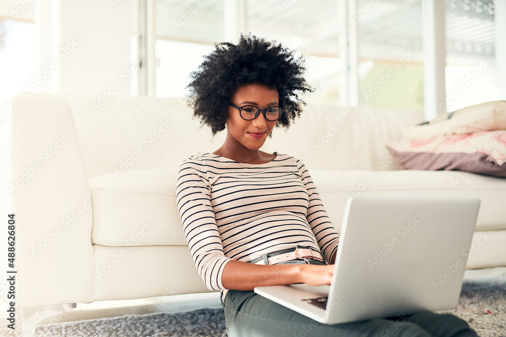 Spending some of her free time online. Cropped shot of a young woman working on her laptop at home. Spending some of her free time online. Cropped shot of a young woman working on her laptop at home.