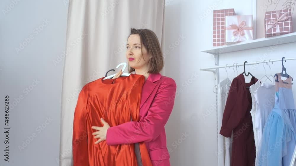 stylish woman trying on dress in showroom