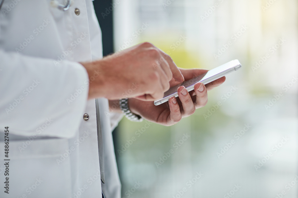 Its one way to keep patients informed. Closeup shot of an unrecognisable doctor texting on his cellphone. Its one way to keep patients informed. Closeup shot of an unrecognisable doctor texting on his cellphone.