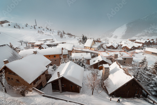 Alpe d'Huez- france. 15-02-2022. The famous ski town of Alpe d'Huez in the French Alps. Wooden houses are covered with snow and fog in the morning.