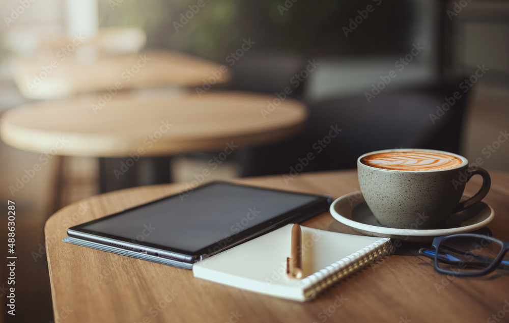 Work from home concept, desk office with digital tablet, blank notepad, eye glasses and coffee cup on wood table Work from home concept, desk office with digital tablet, blank notepad, eye glasses and coffee cup on wood table