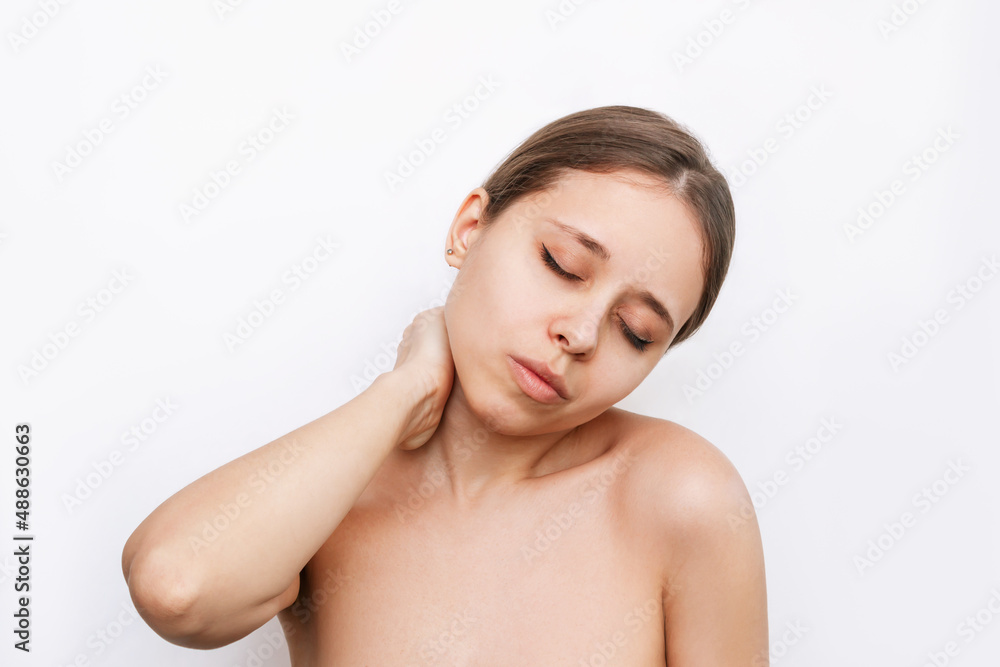 A young attractive caucasian blonde woman with a neck pain holding her neck isolated on white background. The girl suffers from an osteochondrosis A young attractive caucasian blonde woman with a neck pain holding her neck isolated on white background. The girl suffers from an osteochondrosis