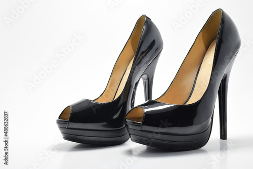 Zapatos negros de tacón alto para mujer. Calzado formal, para fiesta o trabajo sobre un fondo blanco. Espacio para texto al lado izquierdo.