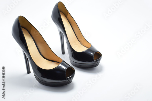 Zapatos negros de tacón alto para mujer. Calzado formal, para fiesta o trabajo sobre un fondo blanco. Espacio para texto al lado derecho, vista superior.