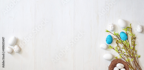 Branches with green leaves and easter eggs on a light background. Happy easter flat lay concept