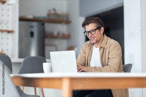 Billede på lærred Happy businessman surfing the Internet on a computer while working at home