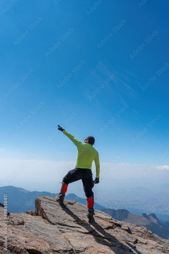 man hiker open arms at mountain peak