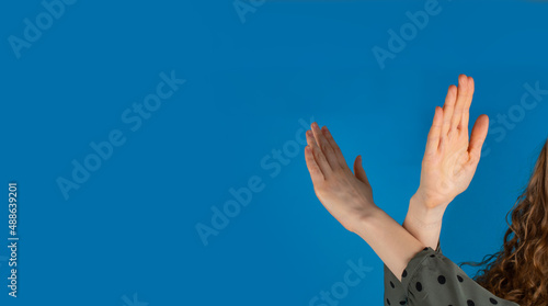 Break the bias symbol of woman's international day. The arms of a girl   are crossed on a blue background.   photo