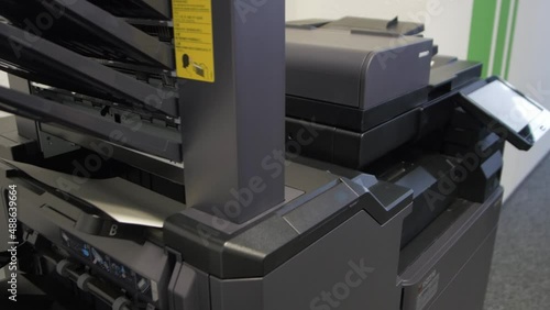 Young man copies documents on a copying system in office