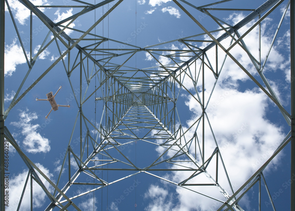 Dron flying over steel electricity pylon