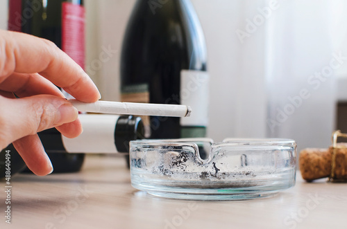 A smoking cigarette in a woman's hand close-up. Concept of unhealthy lifestyle.