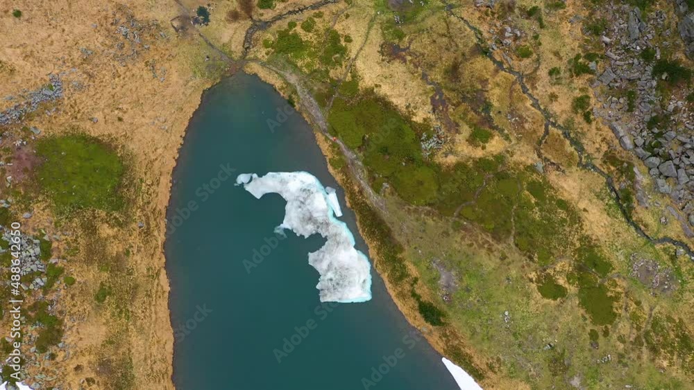 The drone flies over the spring lake Berbeneskul on the Chernogora ridge in the Carpathians, Ukraine, snowy fields, wild peaks. The drone flies over the spring lake Berbeneskul on the Chernogora ridge in the Carpathians, Ukraine, snowy fields, wild peaks.