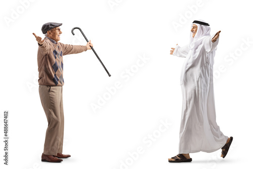 Full length profile shot of an arab man walking with open arms towards an elderly man