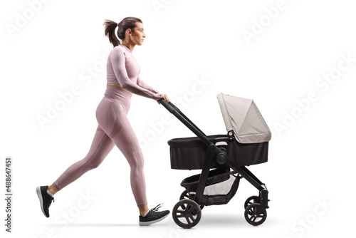 Фотография Full profile shot of a fit mother in crop top and leggings running with a baby s