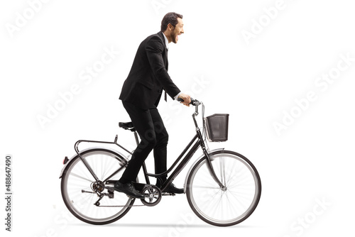Profile shot of a businessman riding a bicycle out of the saddle