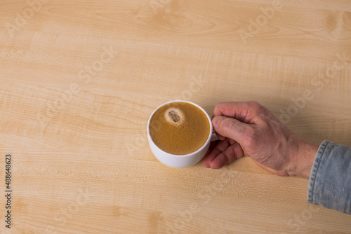 Close up view of man's hand holding cup of coffee. Sweden. 