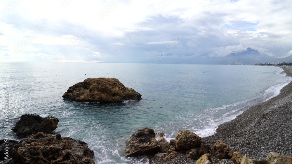 Crystal clear turquoise water, waves crashing on the rocky shore, and the ruins