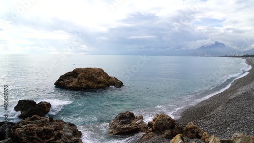 Crystal clear turquoise water, waves crashing on the rocky shore, and the ruins photo