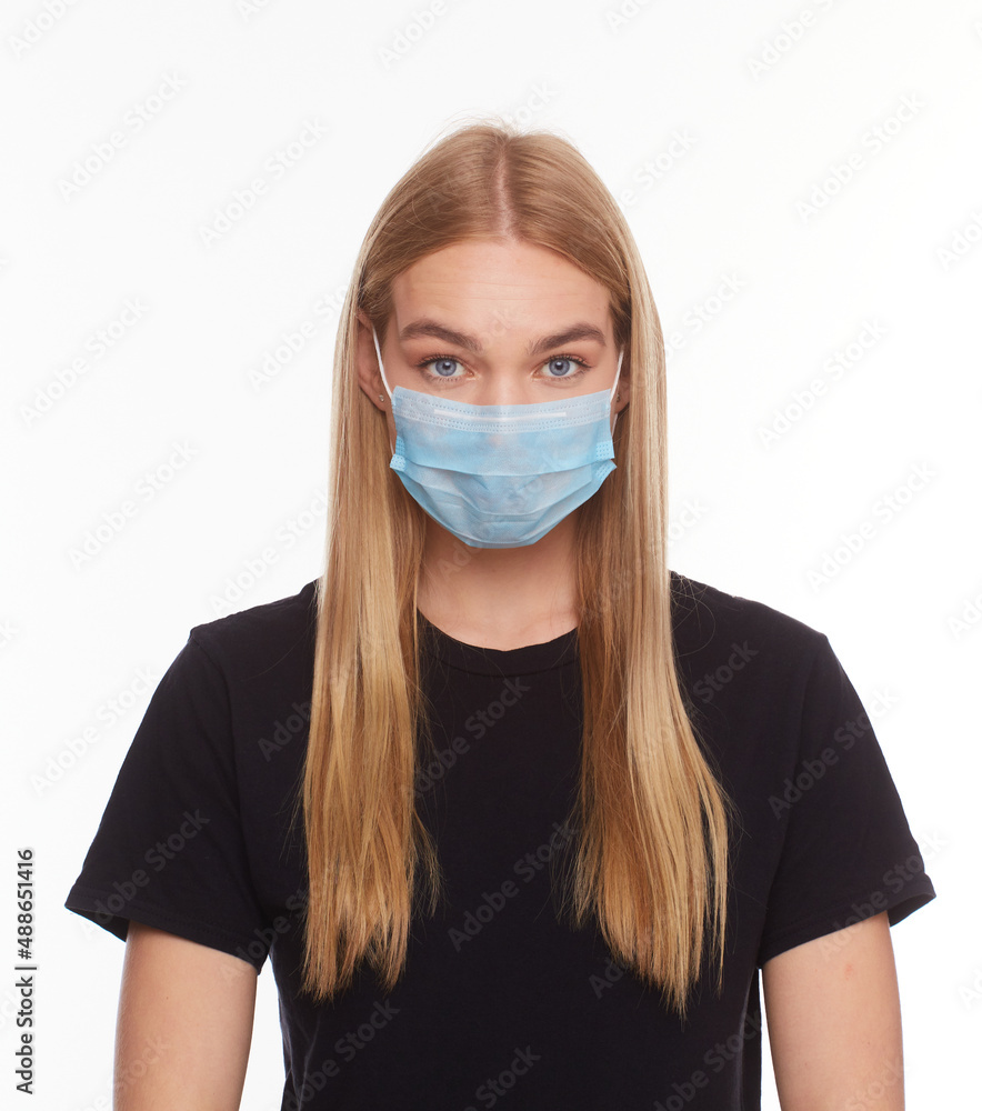 portrait of serious young woman face in a protective medical mask on white studio background, girl sad eyes portrait of serious young woman face in a protective medical mask on white studio background, girl sad eyes