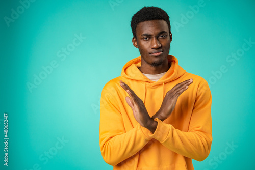 Young african man show arms no refuse decline symbol in studio