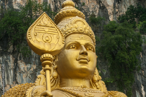 Close up of face of the Murugan Statue (Tugu Dewa Murugga) in Batu Caves, Selangor, Kuala Lumpur. Tallest statue of a Hindu deity in Malaysia made with 300 liters of Gold Paint and 350 tons steel bar. photo