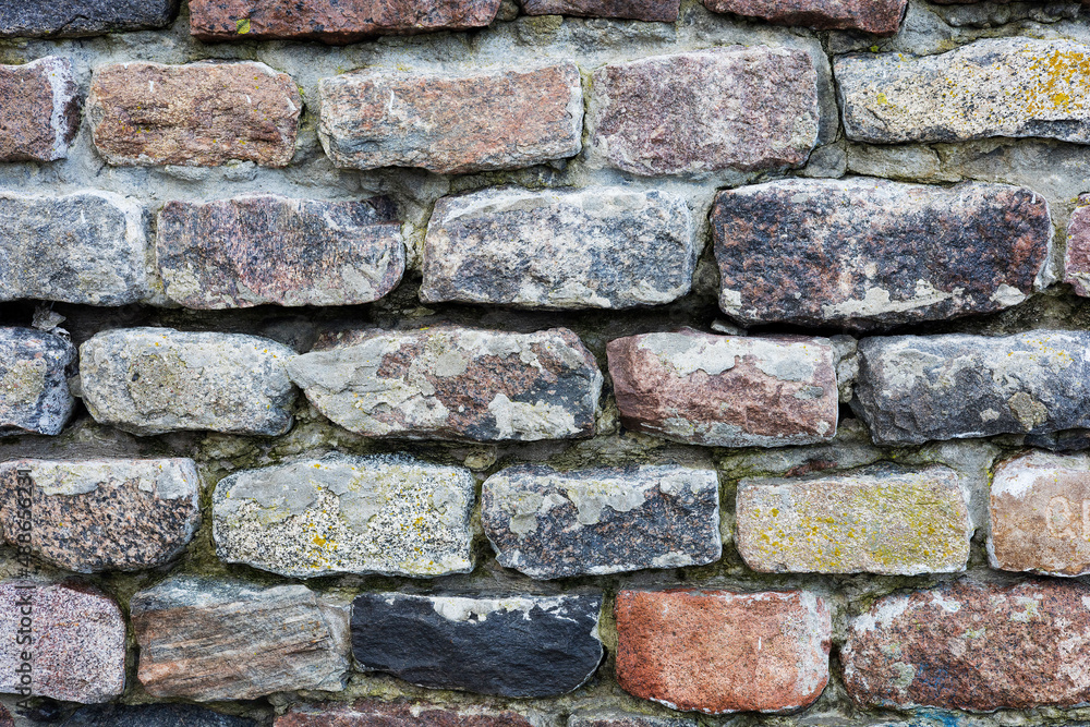 The rough textured surface of the wild stone wall. Background. The rough textured surface of the wild stone wall. Background.