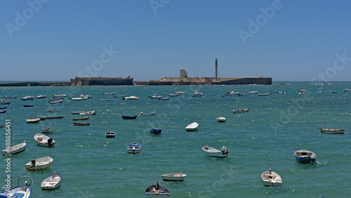 Castle of San Sebastian, sea fort on the coast of in Cadiz, with many dinghy's in front photo