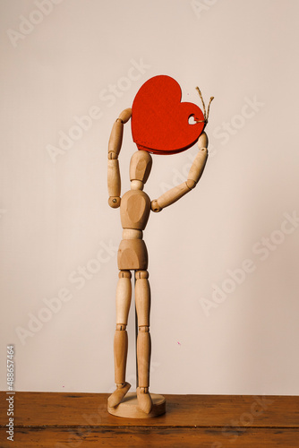 Wooden mannequin with red flower photo