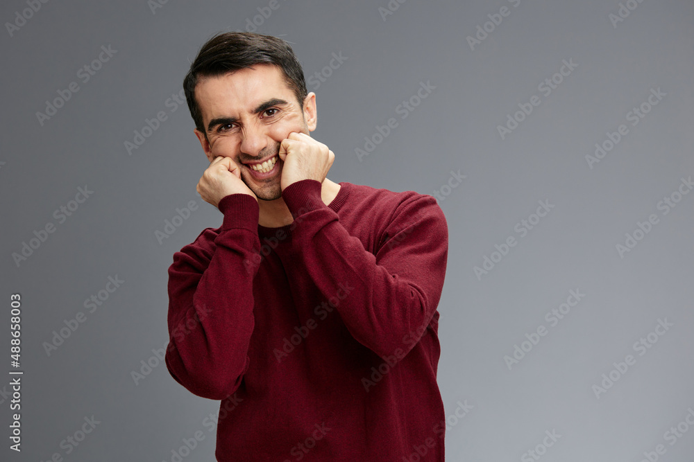 manager in a red sweater holding hands near face gesturing with hands posing isolated background manager in a red sweater holding hands near face gesturing with hands posing isolated background