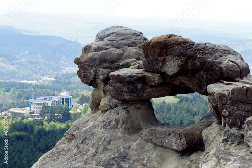 A stone ring as a figure, on the edge of the abyss. The forest bloomed in the mountains after winter.