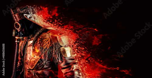 Photo of fantasy post apocalyptic raider warrior with armored outfit jacket, scrap crown and gas mask standing and dissolving with fire effects on black background.