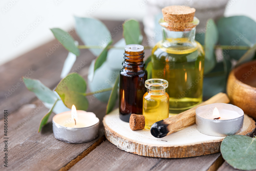 Assortment of natural oils in glass bottles on wooden background. Concept of pure organic ingredients in cosmetology. Bath accessories, atmosphere of harmony, relax. Close up macro. Healthy lifestyle Assortment of natural oils in glass bottles on wooden background. Concept of pure organic ingredients in cosmetology. Bath accessories, atmosphere of harmony, relax. Close up macro. Healthy lifestyle
