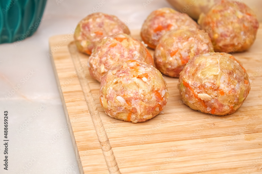 Lazy stuffed cabbage rolls, cabbage, rice on a wooden cutting board on the table. Meatballs with cabbage. Lazy stuffed cabbage rolls, cabbage, rice on a wooden cutting board on the table. Meatballs with cabbage.