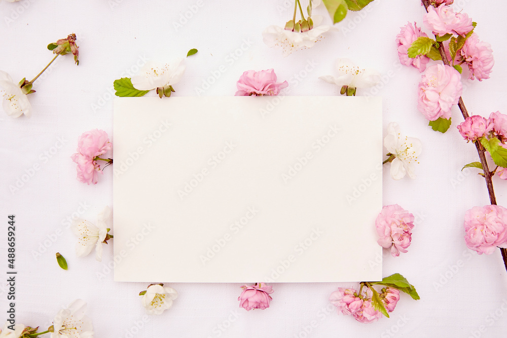 Feminine stationery card mockup with spring white and pink delicate flowers. Romantic, wedding, birthday, invitation, mother's day mock up card concept. Copy space. Top view.