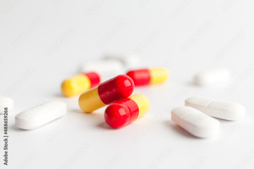 Colorful and white pills on a white background Colorful and white pills on a white background