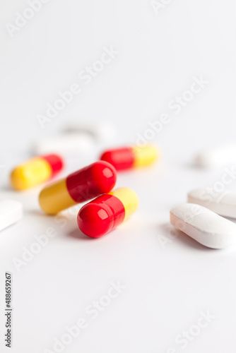 Colorful and white pills on a white background