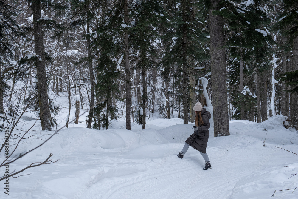 Girl walking in the snowy forest.