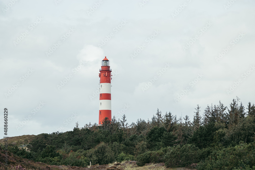 Hinter Dünen und Wälder sieht man den Leuchtturm am Horizont Hinter Dünen und Wälder sieht man den Leuchtturm am Horizont