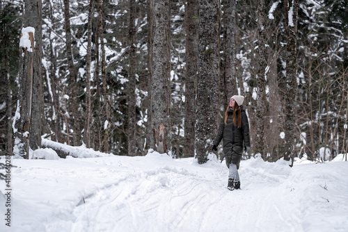 Girl walking in the snowy forest.