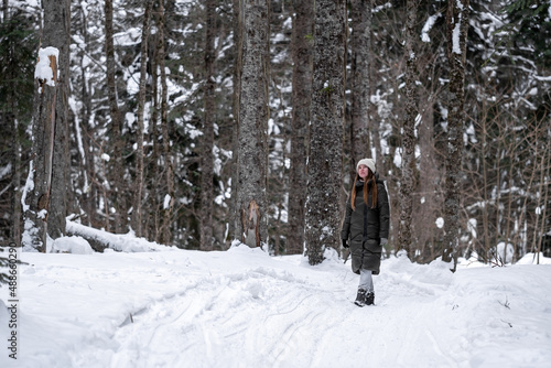 Girl walking in the snowy forest.