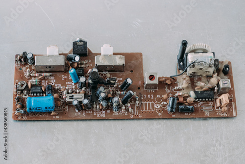 Old non-working microcircuit on a metal table. Repair disassembly of electrical equipment.