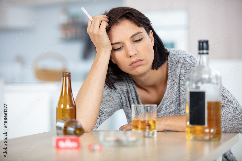 depressed young woman drinking alcohol and smoking cigarette at home depressed young woman drinking alcohol and smoking cigarette at home