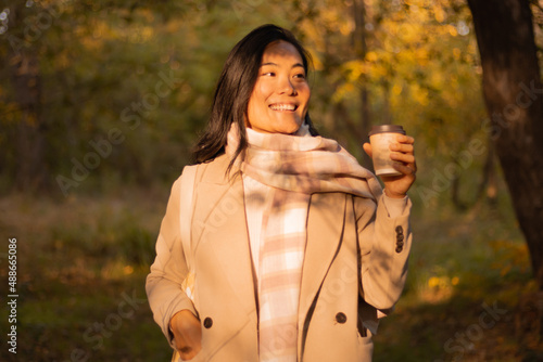 Joyful young woman happy to see someone on her coffee break outside in the park.