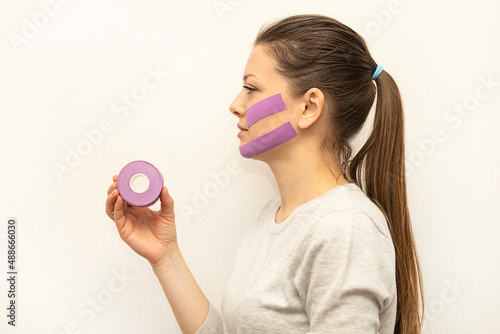 Bild auf Leinwand Portrait of a pretty woman with kinesio taping on her face