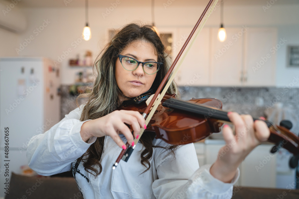 One woman front view portrait of adult caucasian female holding violin at home learning to play music and practice concept real people copy space One woman front view portrait of adult caucasian female holding violin at home learning to play music and practice concept real people copy space