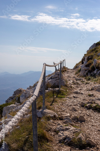 Pedestrian road in the mountains of Croatia with rope fence, vertical orientation