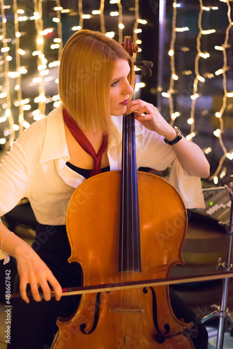 Young woman playing cello on the concert