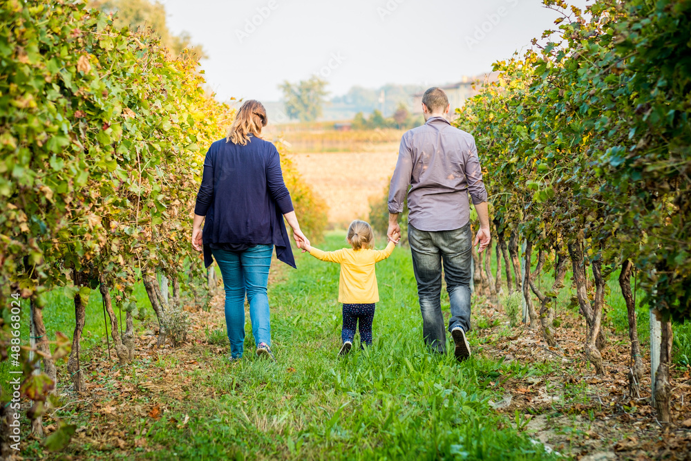 Happy family taking a walk at vineyard. Sunny autumn day Happy family taking a walk at vineyard. Sunny autumn day