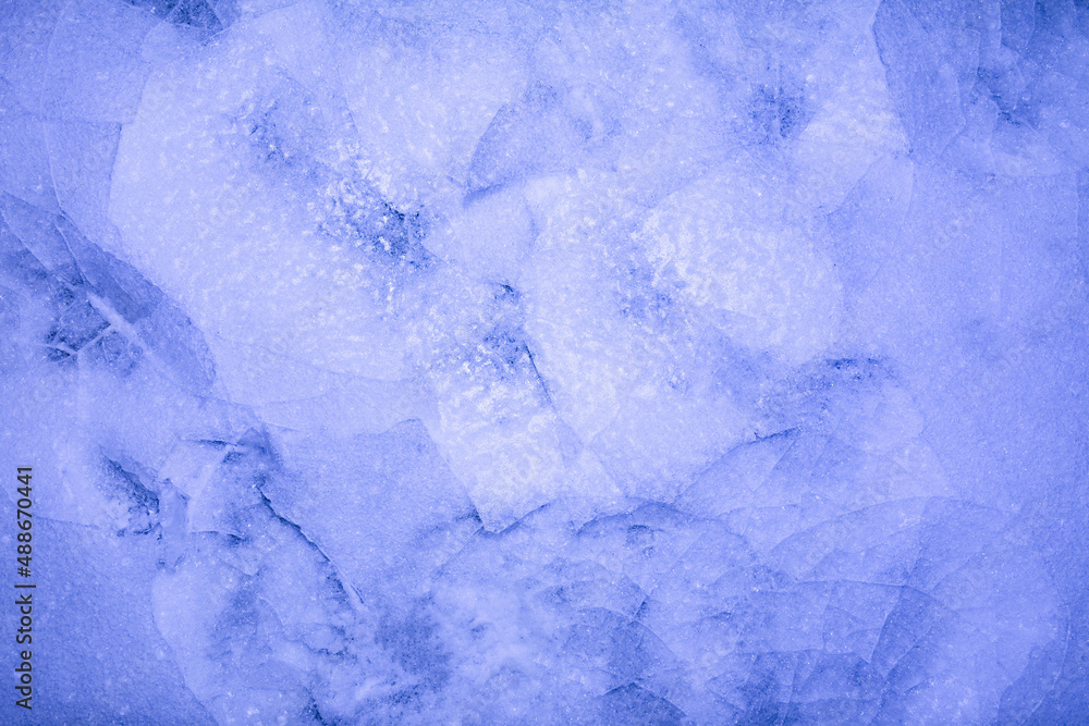 Photo of blue toned frozen cracked ice ground texture with footprint. Photo of blue toned frozen cracked ice ground texture with footprint.